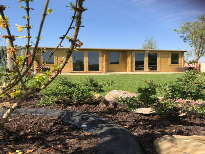 Photo of the log cabin and garden at Green Meadow Dog Day Care